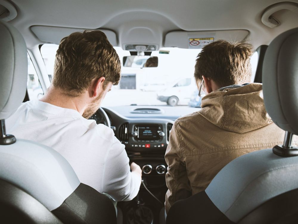 Instrutor e aluno conferindo o painel do carro antes de começar a aula.